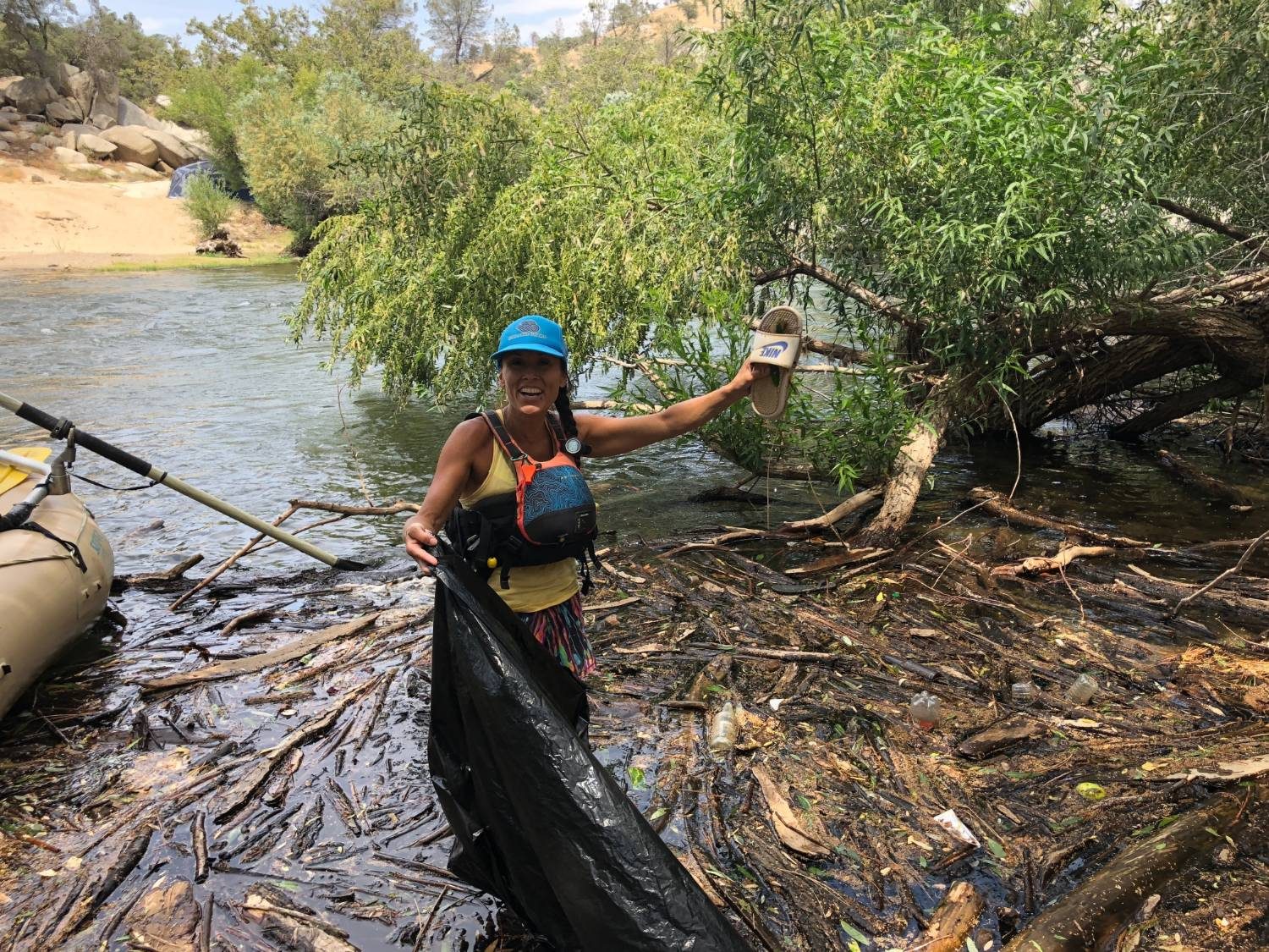 Daneya Williams in guide gear pulling trash out of the Kern River